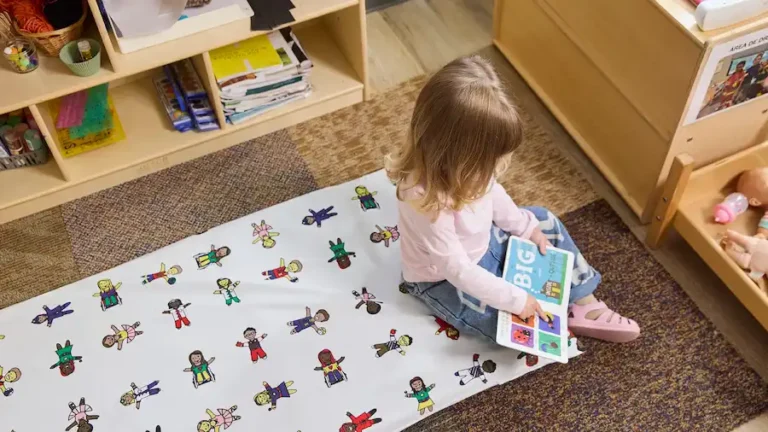 Child reading on rest mat in classroom with rest mat sheet in multicultural theme